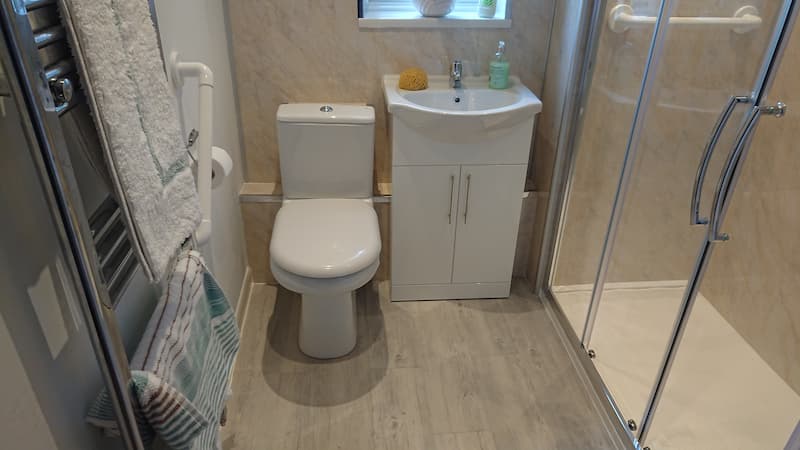 modern bathroom with wooden flooring and double door shower