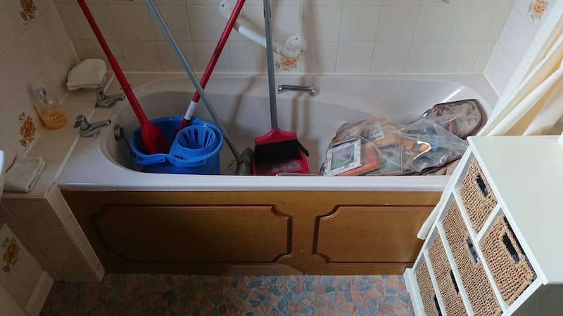cluttered bath filled with bucket and mop